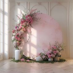 an artistic display with pink flowers and greenery on the side of a large round object