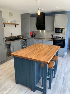 a kitchen with two stools next to an island in the middle of the room