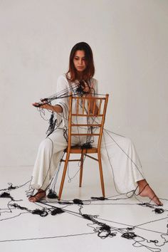 a woman is sitting on a chair with wires all over her