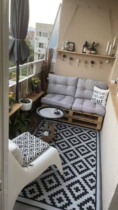 an apartment balcony with white furniture and black and white rugs on the flooring