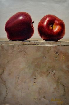 two red apples sitting on top of a stone counter next to each other in front of a white wall