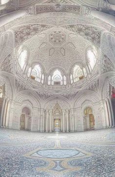 the inside of an ornate building with high ceilings and intricate designs on the ceiling,