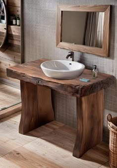 a bathroom sink sitting under a mirror next to a wooden table with a white bowl on it