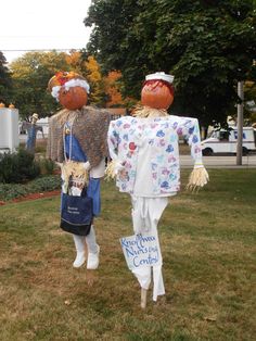 two scarecrows are standing in the grass with their heads turned to look like they're dressed for halloween