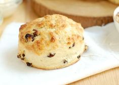 a muffin sitting on top of a white napkin next to a bowl of oatmeal