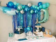 a table topped with blue and silver balloons