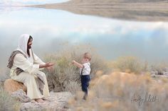 a woman and child are sitting on rocks near the water