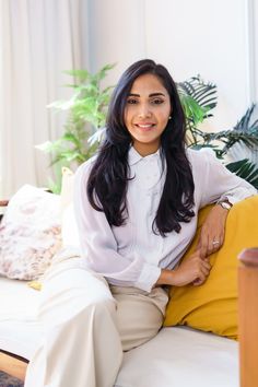 a woman sitting on top of a white couch