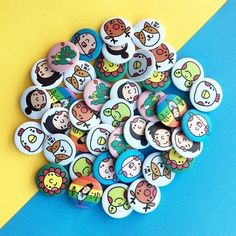 a pile of cartoon buttons sitting on top of a blue and yellow table