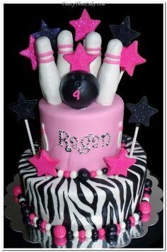 a birthday cake decorated with bowling pins and pink, black and white stars on top