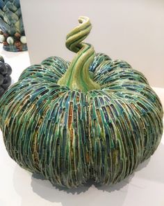 a ceramic pumpkin sitting on top of a white table