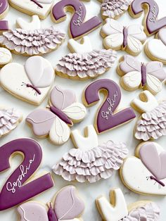 cookies decorated with purple and white icing are displayed