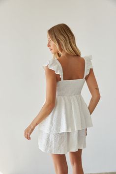 Get ready for sunny days in the Ashlyn Sweetheart Ruffle Fit and Flare Mini Dress! This white mini dress features a feminine sweetheart neckline, delicate flutter sleeves, and a flattering fit and flare silhouette. Unique with a floral texture and double tiered skirt, this white babydoll dress is ready to bloom! Accessorize to complete the look!Details 100% Polyester Elastic straps Smocked back panel Partially lined Hand wash cold/ hang dry White Mini Dress With Sweetheart Neckline And Ruffles, White Mini Dress With Ruffles And Sweetheart Neckline, Feminine Mini Dress With Sweetheart Neckline For Vacation, Feminine Mini Dress With Smocked Back And Sweetheart Neckline, Sweetheart Neckline Ruffle Mini Dress For Day Out, White Mini Dress With Ruffle Hem And Sweetheart Neckline, Feminine Flutter Sleeve Mini Dress For Vacation, Summer Mini Dress With Flutter Sleeves For Garden Party, Summer Mini Dress With Flutter Sleeves For Brunch