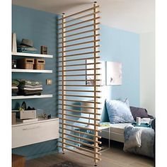 a living room with blue walls and white shelving units on the wall, along with bookshelves