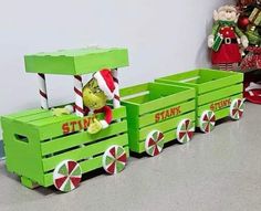 a green wooden toy train with santa's helper on it