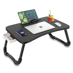 a computer desk with a laptop, mouse and drink on it next to an ipad