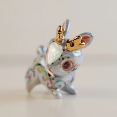 a silver and gold rabbit figurine sitting on top of a white countertop