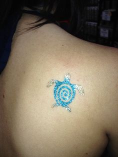 the back of a woman's shoulder with a tattoo on it