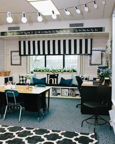 an office decorated with black and white striped curtains, desks, chairs, and bookshelves