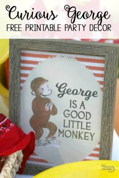 there is a sign that says george is a god little monkey on the table with other decorations