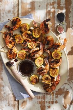 grilled shrimp and zucchini skewers on a plate with dipping sauce