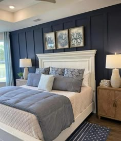 a bedroom with blue walls and white bedding