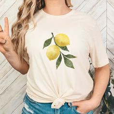 Celebrate retro style with our Vintage Lemon Shirt--featuring a charming Lemon design, perfect for a fresh, nostalgic look. IMPORTANT INFORMATION - DTG printing - 100% preshrunk cotton - Wash and dry normally (on cool for best results) - Do not bleach - Tumble dry: low heat; - Do not dryclean * S I Z I N G * - Models are wearing size small (some photos tee is knotted to the side, but it is sent untied, regular length) - Sizing is unisex so runs like men's, though not overly large - Most women fi White Short Sleeve Top With Lemon Print, White Short Sleeve T-shirt With Lemon Print, White Crew Neck T-shirt With Lemon Print, Yellow Lemon Print Crew Neck Top, Cotton Graphic Tee With Lemon Print, Short Sleeve Lemon Print Graphic Tee, Yellow Crew Neck Top With Lemon Print, Spring Cotton T-shirt With Lemon Print, Cotton T-shirt With Lemon Print, Short Sleeve