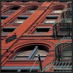 an old building with red brick and wrought iron railings