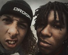 two people with dreadlocks are making faces