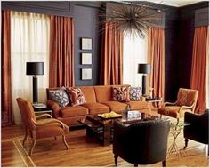 a living room filled with furniture and orange curtains