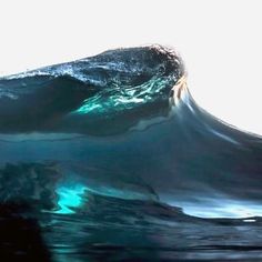 an ocean wave is seen in this artistic photo with the light reflecting off it's surface