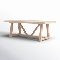 a wooden table sitting on top of a white floor covered in light colored wood planks