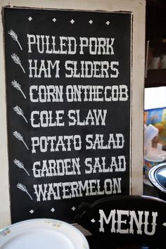 a menu sign on the wall next to plates