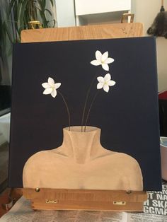 an easel holding a painting with flowers in it