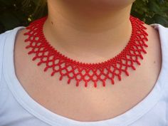 a woman wearing a red beaded necklace