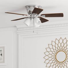 a ceiling fan mounted to the side of a white wall next to a framed photograph