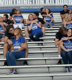 some people are sitting on bleachers and hugging