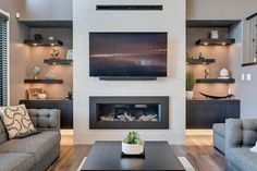 a living room with two couches and a flat screen tv mounted on the wall