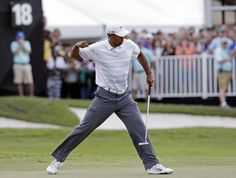 a man holding a golf club on top of a green