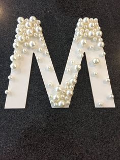 the letter m is made out of pearls