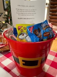 a red bucket filled with snacks on top of a table