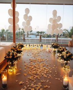 a table with flowers, candles and balloons on it