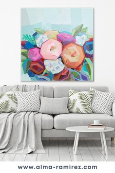 a living room with a couch and painting on the wall above it that has flowers in different colors