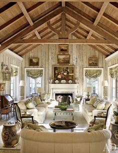 a living room filled with furniture and a fire place in the middle of a room