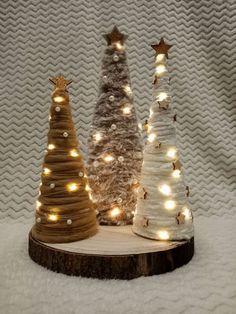 three small christmas trees with lights on them