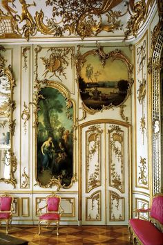 an ornately decorated room with pink chairs and paintings on the walls, along with gold trimmings