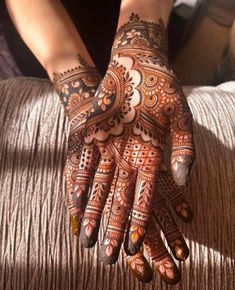 a woman's hand with henna tattoos on it