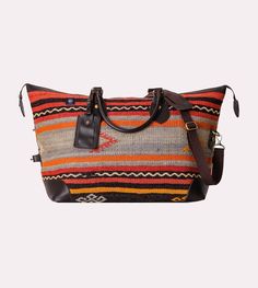 Description: Inspired by a visit to Istanbul, each kilim weekender bag is one-of-a-kind, handmade from vintage 50-to-100 year old handwoven Turkish rugs. Each weekender bag includes a button down side strap, a leather trimming and leather bottom, a woven cross-body shoulder strap, and a YKK zipper (Yoshida Kogyo Kabushikikaisha). Turkish kilim is extremely durable which will provide for long lasting traveling. Because each Turkish rug is unique, no two bags will ever be identical. This bag is the perfect airline carry-on size, with an international flair. Weekender bag dimensions are 24" x 16" x 9". AVAILABLE TO SHIP DECEMBER 22. Details & Care: Our weekender bag pays homage to the 'Bogie' bag. In 1947, Humphrey Bogart commissioned a personalized canvas and leather duffel bag which became Brown Weekender Bag With Top Carry Handle For Trips, Brown Weekender Bag With Detachable Handle, Brown Weekender Bag With Detachable Handle For Travel, Vintage Weekender Bag With Leather Trim For Daily Use, Rectangular Weekender Bag With Braided Handles For Travel, Travel Weekender Bag With Braided Handles, Leather Trim Tote Travel Bag, Brown Weekender Bag For Weekend Trips, Travel Tote Bag With Leather Trim