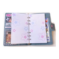 an open notebook with pink, blue and white stars on the pages is shown in this image