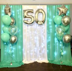 balloons and streamers in front of a backdrop with the number 50